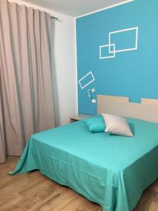 a bedroom with a bed with a blue background at Ai Gradini Affittacamere in Castellammare del Golfo