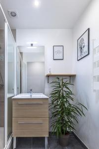 a bathroom with a sink and a potted plant at ESCAPE time - Paris in Gentilly