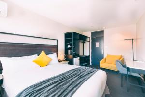 a bedroom with a bed and a desk and a yellow chair at Haven Glebe in Sydney