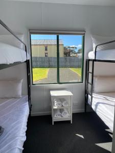 a room with two bunk beds and a window at Swansea Holiday Park Tasmania in Swansea