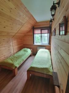 シェレゲシュにあるДом в кедрах 1の木造キャビン内のベッド2台が備わる部屋