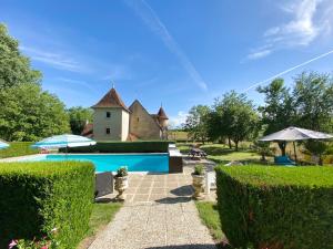 einen Garten mit einem Haus und einem Pool in der Unterkunft Le Petit Chateau De Sainte Colombe in Bouges-le-Château
