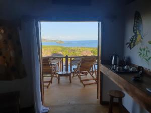 a kitchen with a view of the ocean from a door at villa nosy détente in Nosy Be