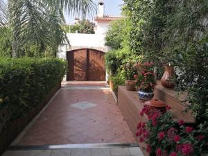 a garden with a wooden gate and some plants and flowers at La Luna Blanca in Torremolinos
