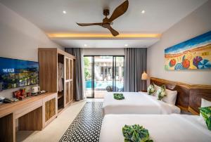 a bedroom with two beds and a ceiling fan at The Kila Boutique Hotel in Quy Nhon