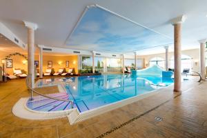 a large pool with a slide in a house at Hotel Seeblick in Goldegg