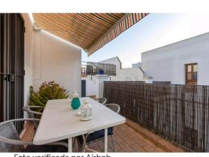une table et des chaises sur une terrasse avec une clôture dans l'établissement Atico padre Aldama centro y con WIFI, à Sanlúcar de Barrameda
