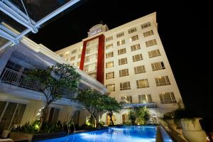 a hotel with a swimming pool in front of a building at Grand Zuri BSD City in Serpong