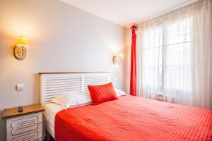 a bedroom with a red bed and a window at Appart'Hotel Saint-Michel in Chartres