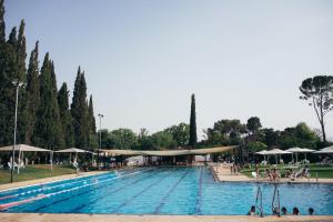 una gran piscina con gente sentada a su alrededor en Pastoral Hotel - Kfar Blum, en Kfar Blum