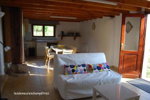 a living room with a white couch and a table at Les demeures champêtres in Jarnosse
