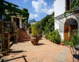 a courtyard with potted plants and stairs in a building at La Valle Delle Najadi in Vietri