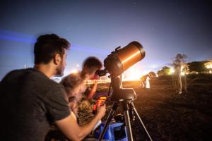 eine Gruppe von Menschen, die mit einem Teleskop die Sterne betrachten in der Unterkunft Pastoral Hotel - Kfar Blum in Kfar Blum