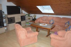 sala de estar con sofá, 2 sillas y mesa en Ferienwohnung Stoiber, en Frauenau