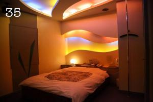 een slaapkamer met een groot bed met verlichting bij HOTEL K's GOMANGOKU adult only 