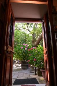 una puerta abierta a un patio con flores rosas en Hotel Filoxenia en Portariá