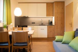 eine Küche und ein Wohnzimmer mit einem Tisch und einem Sofa in der Unterkunft Ferienwohnung Carmen Schuchter in Vandans