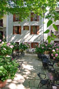 波爾塔里亞的住宿－Hotel Filoxenia，一座建筑前带桌椅和鲜花的庭院