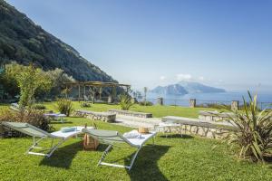a garden with two chairs and a table and a swing at VILLA CAMPANELLA - Sorrento Capri Positano - Exclusive Pool and garden in Massa Lubrense