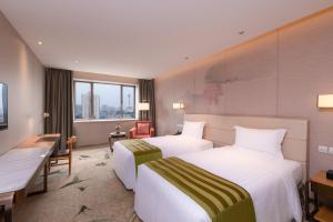 a hotel room with two beds and a desk at Guanganmen Grand Metropark Hotel Beijing in Beijing