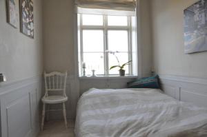 a bedroom with a bed and a chair and a window at ApartmentInCopenhagen Apartment 331 in Copenhagen
