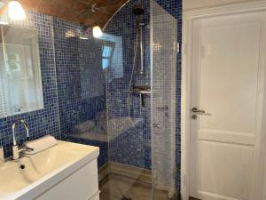 a bathroom with a sink and a shower with blue tiles at Urlaubsmühle Fortuna St. Peter-Ording in Borsthusen