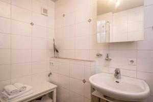 ein weißes Badezimmer mit Waschbecken und Spiegel in der Unterkunft Ferienwohnung Lilian in Meckenbeuren + 15 Fotos