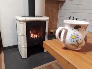 a coffee cup sitting on a table next to a stove at Chatky u potoka, chatička č. 1 in Olešnice v Orlických horách