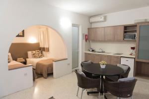 eine Küche und ein Schlafzimmer mit einem Bett und einem Tisch in der Unterkunft Sands Apartments in St Paul's Bay
