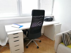 Un escritorio con una silla en una habitación con ventana. en City centre studio with a balcony and free parking, en Liubliana 2 fotos más