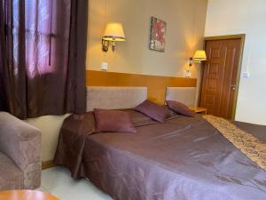 ein Schlafzimmer mit einem großen Bett mit violetter Bettwäsche in der Unterkunft Monalysa St Honore Apartment & Studios Grand Bay in Grand Baie
