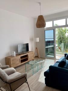 ein Wohnzimmer mit einem TV und einem Sofa in der Unterkunft Casa Carla in Arrecife