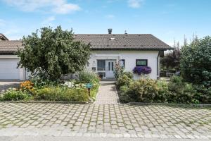 a white house with a garden in front of it at Ferienwohnung Irmi in Hergensweiler