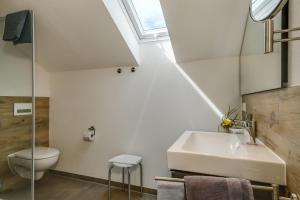 a bathroom with a sink and a toilet and a window at Ferienwohnung Irmi in Hergensweiler