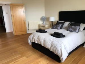 a bedroom with a large bed with two black towels on it at Stunning Penthouse with Sea Views - Close to the Beach, Sea & Bars ,Restaurants & Shops in Leigh-on-Sea