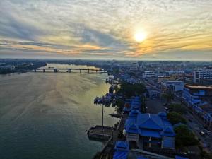 Blick auf einen Fluss mit einer Brücke und eine Stadt in der Unterkunft Muar Traders Hotel in Muar