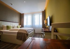 ライプツィヒにあるアパートメント セントラル ライプツィヒのベッドとデスクが備わるホテルルームです。