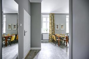 a dining room with tables and chairs and a door at Żółty Apartament DE LUX dla 2 osób Chorzów Katowice in Chorzów