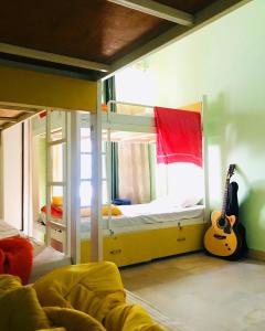 a bedroom with two bunk beds and a guitar at The Desire Hostel in New Delhi