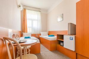 a small room with two beds and a table and a tv at Eitans Guesthouse in Budapest