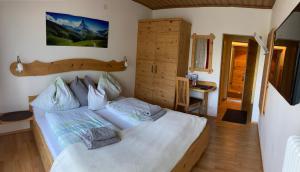 a bedroom with a large white bed and a desk at Haus Voithofer in Sankt Johann im Pongau