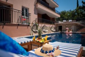 a hat sitting on a table next to a swimming pool at Villa Providenca in Čelopeci