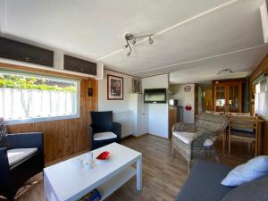 een woonkamer met een bank en een tafel bij Ferienpark Vislust Ferienhaus Balu mit eigenem Steiger zum angeln Ijsselmeer Niederlande in Wervershoof