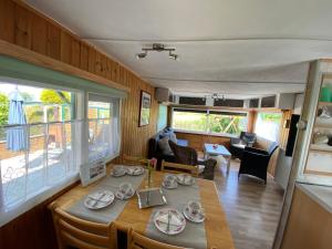 een eetkamer en een woonkamer met een tafel en stoelen bij Ferienpark Vislust Ferienhaus Balu mit eigenem Steiger zum angeln Ijsselmeer Niederlande in Wervershoof