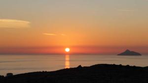a sunset over the ocean with a mountain in the distance at Hotel Aglaia in Kalamaki