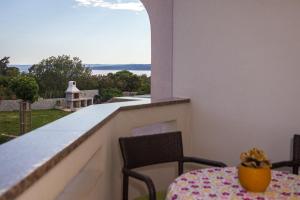 stół i krzesła na balkonie z widokiem w obiekcie Apartmani Manzoni w mieście Punat