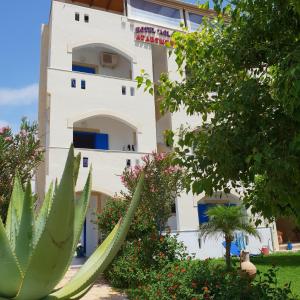 a white building with a plant in front of it at Hotel Aglaia in Kalamaki
