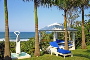 a gazebo with a blue chair and a statue at Days At Sea Beach Lodge in Trafalgar