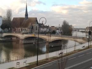 most nad rzeką z kościołem i ulicą w obiekcie Chambre privée dans maison centre-ville Sens Petit-déjeuner compris w mieście Sens