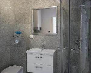 ein Badezimmer mit einem WC, einem Waschbecken und einem Spiegel in der Unterkunft Wisełka Apartamenty Sea & Lake in Wisełka